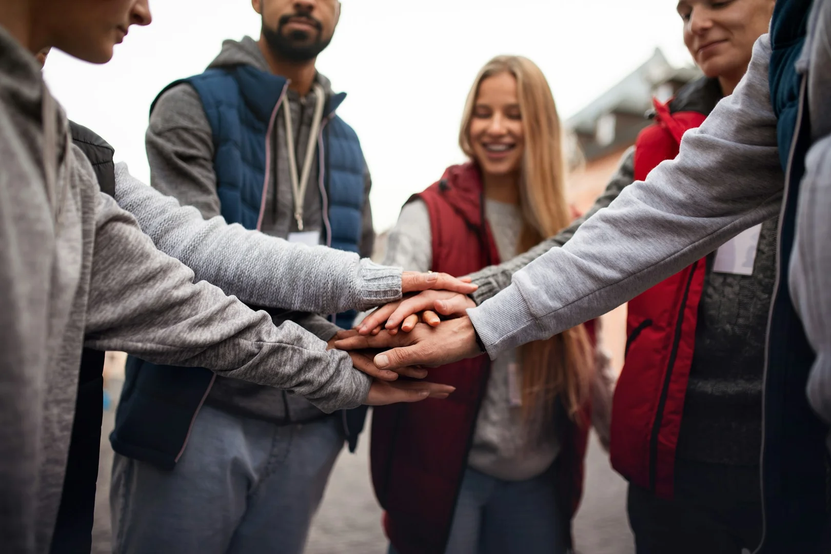 Community members placing hands together to show support for Calgary school and local vendor partnerships.