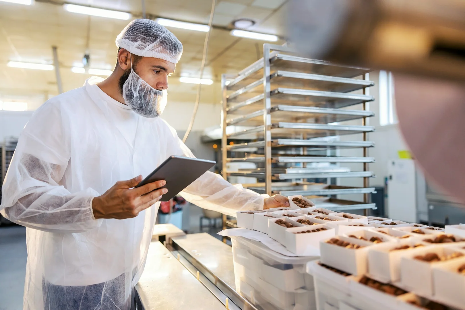 Worker checking food safety and packaging for school lunch meal preparation.