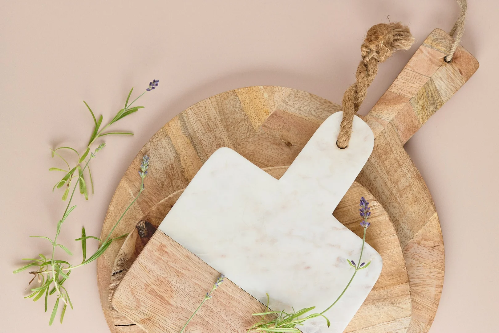 Stacked wooden and marble cutting boards with herbs, used for simple lunch prep routines.