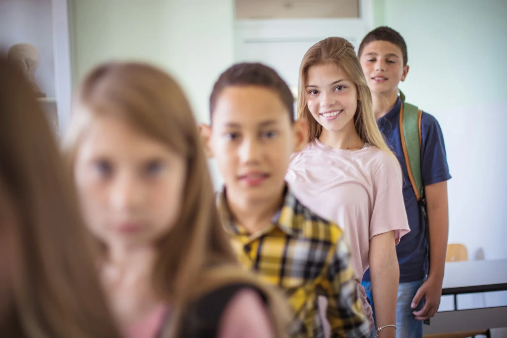 Smiling school children standing in line, representing safe and accessible lunch options for all students.