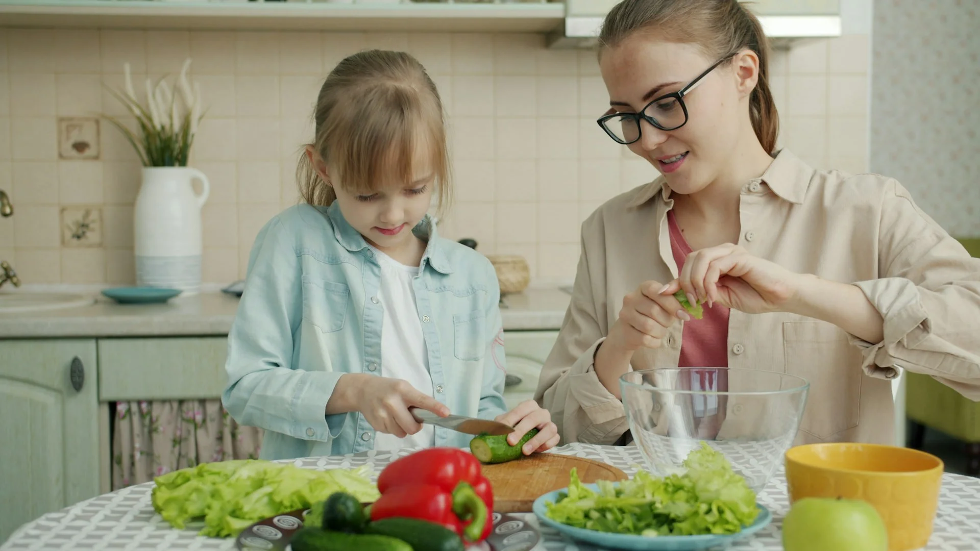 Parent and child cooking together and preparing vegetables for a healthy vegetarian school lunch.