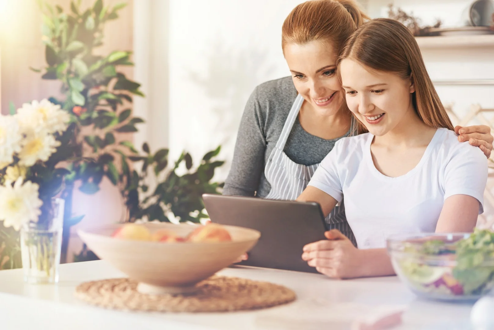 Parent and child looking at a tablet together at home.