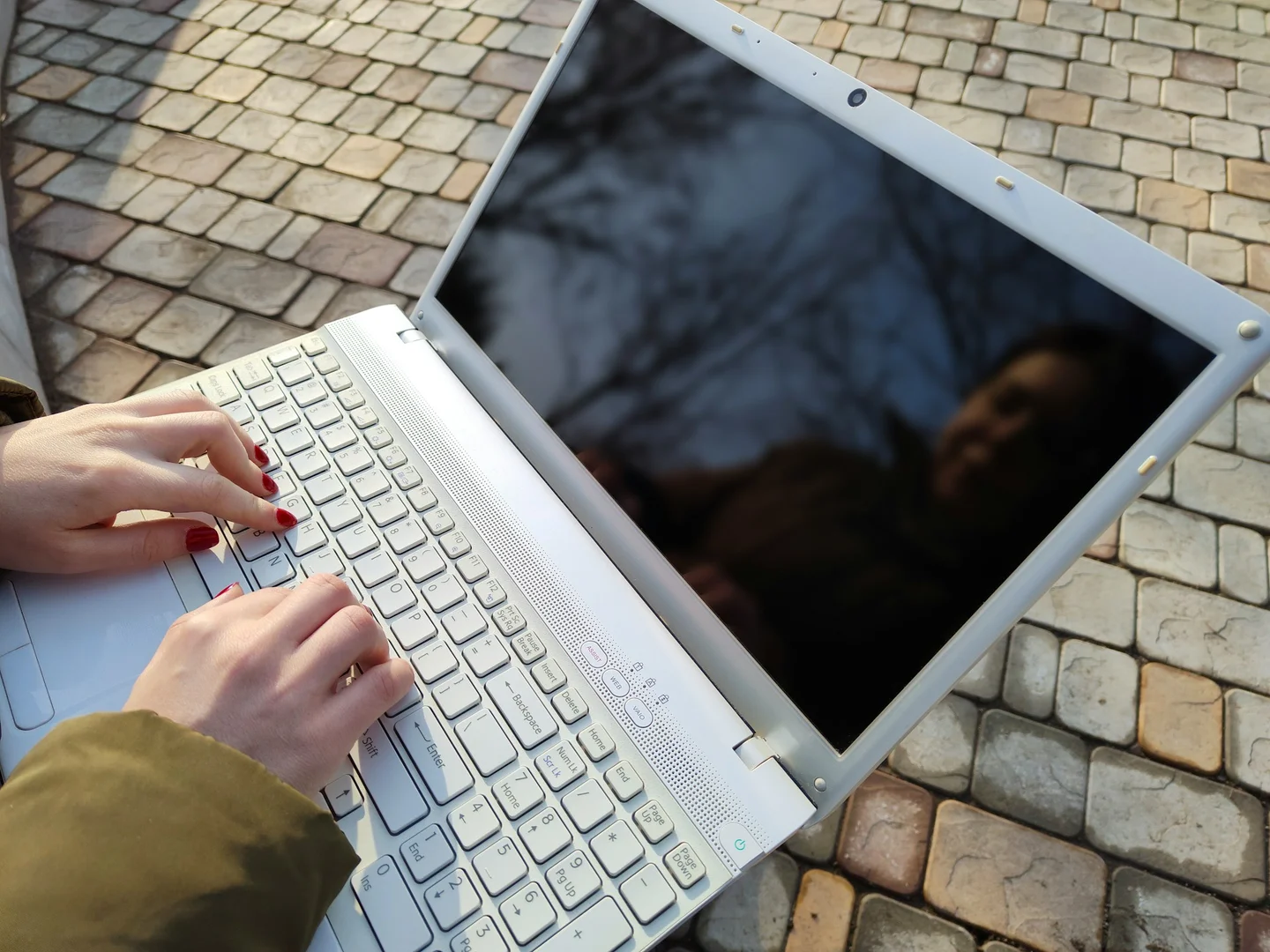 Close-up of a parent’s hands typing on a laptop to place a school lunch order.