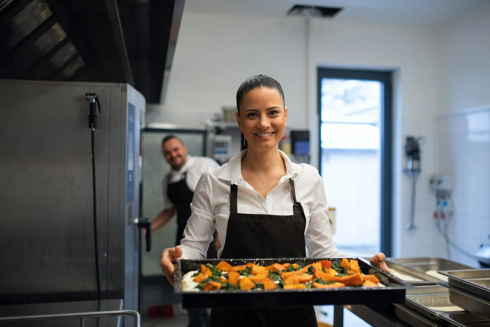 Restaurant chef preparing a tray of food for school lunch catering service.