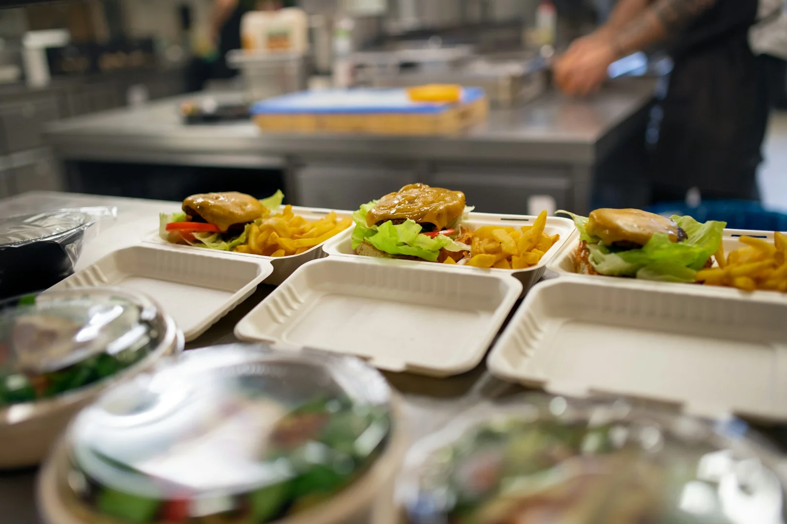 Prepared meal boxes in a restaurant kitchen for a school hot lunch program partnership.