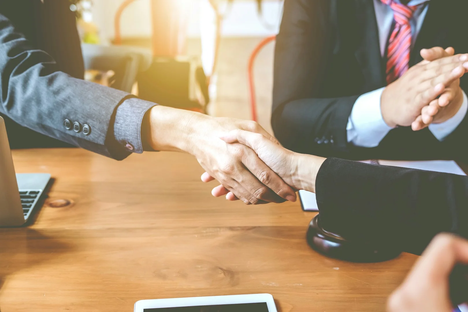 Restaurant and school representatives shaking hands to form a lunch program partnership.