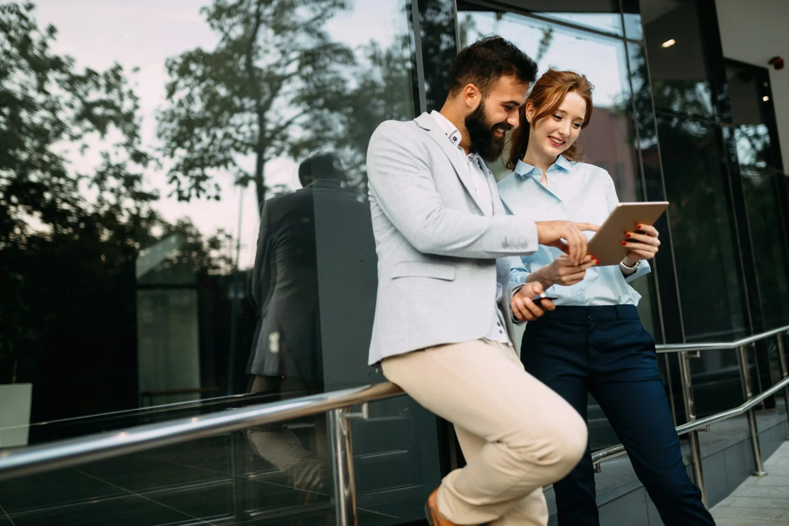 Two school administrators reviewing lunch management data on a tablet as part of digital system adoption.