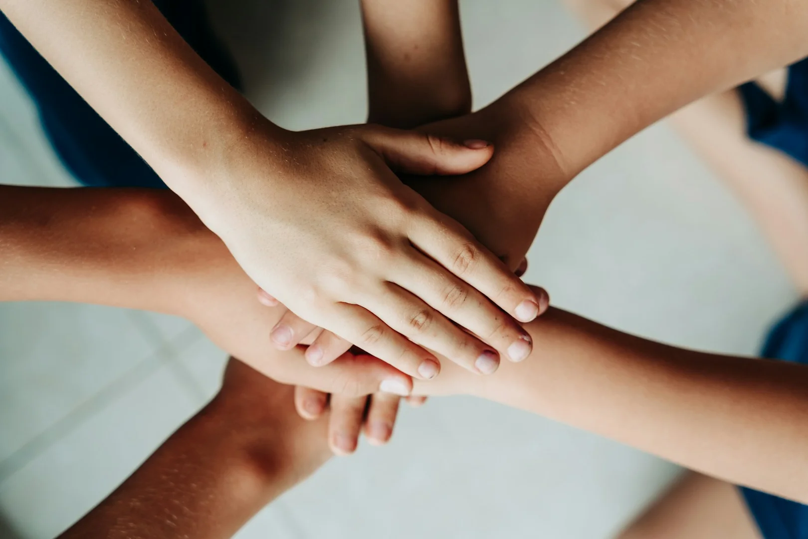 Students and volunteers joining hands to celebrate successful school fundraising teamwork.