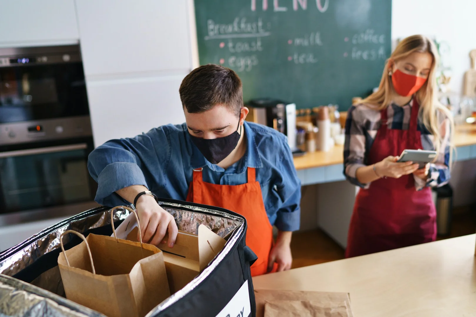 Volunteers packing hot lunch meal boxes for a school fundraising program.