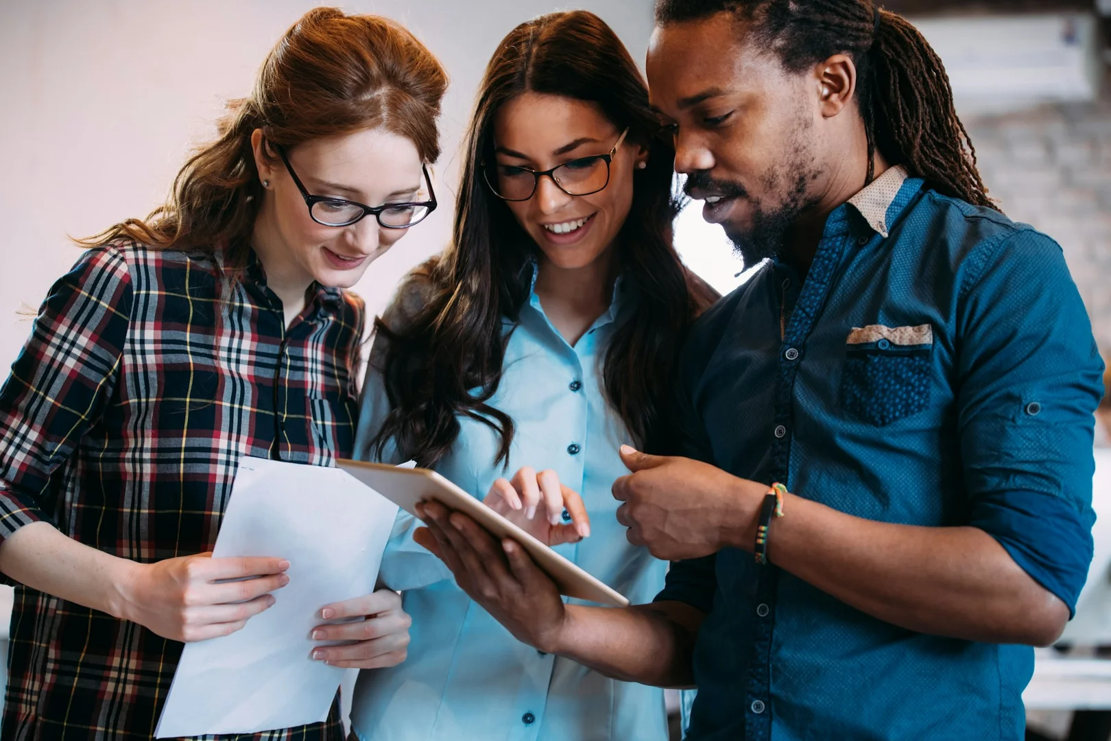 School staff reviewing lunch program information together using a digital tablet.