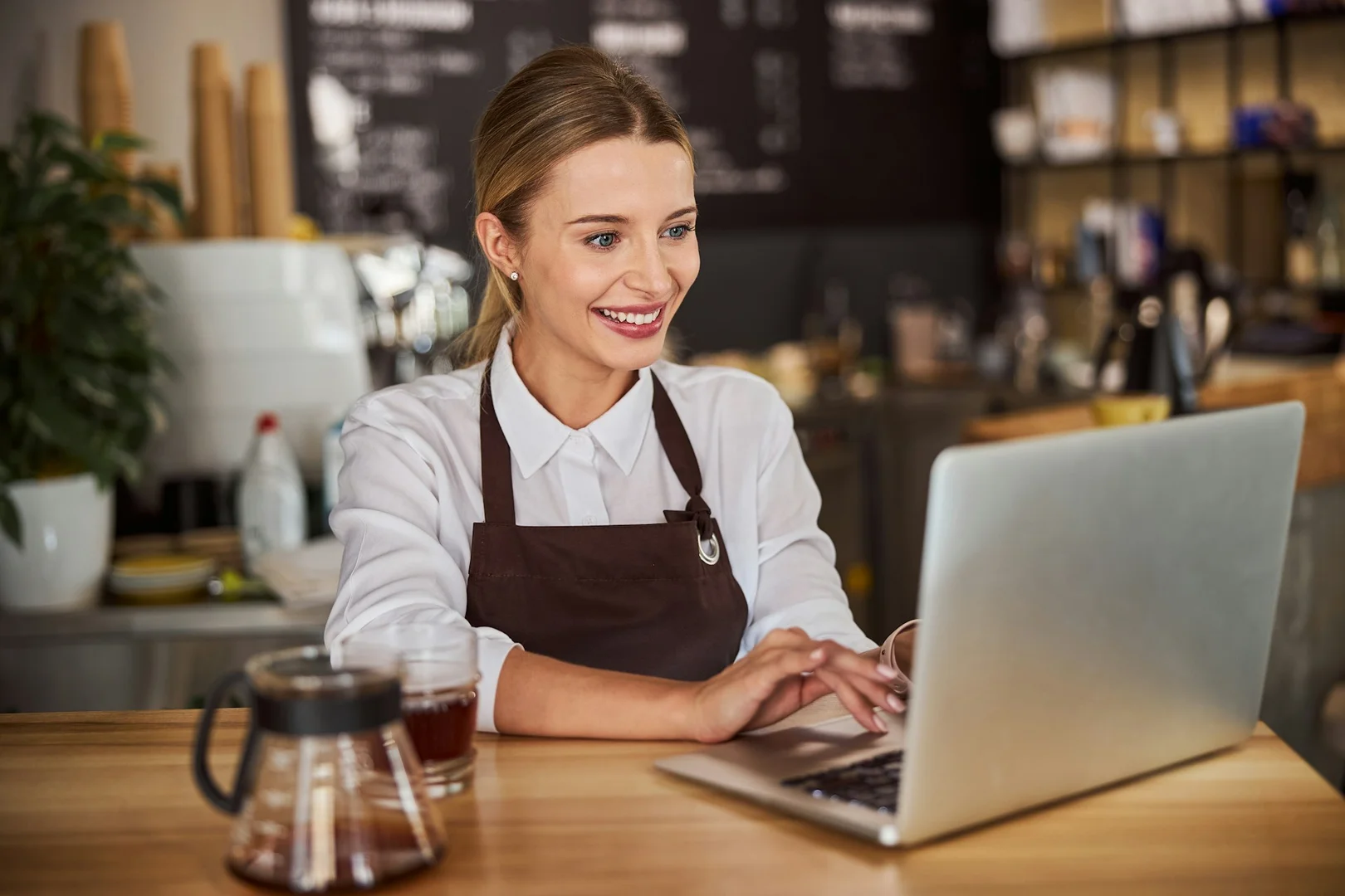 Restaurant staff using computer to manage school lunch orders through an online system.