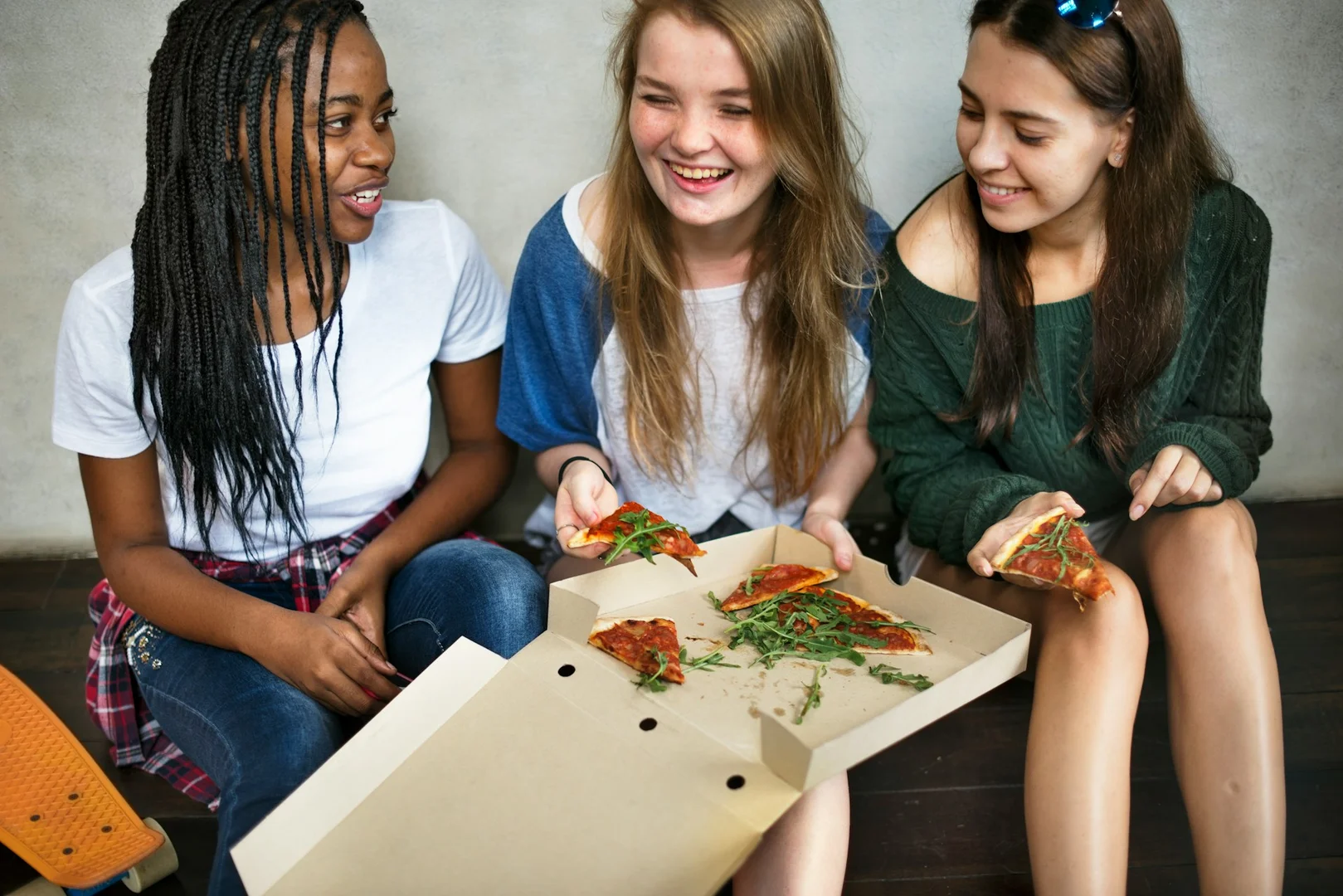 Group of students enjoying pizza together during a school hot lunch fundraiser.